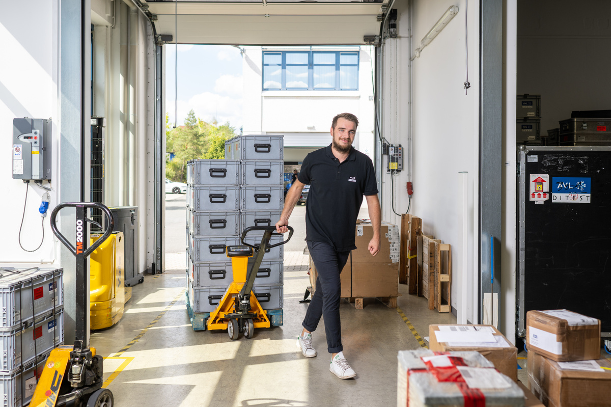 Logistikmitarbeiter mit Pendelverpackungen im AVL DiTEST Servicecenter